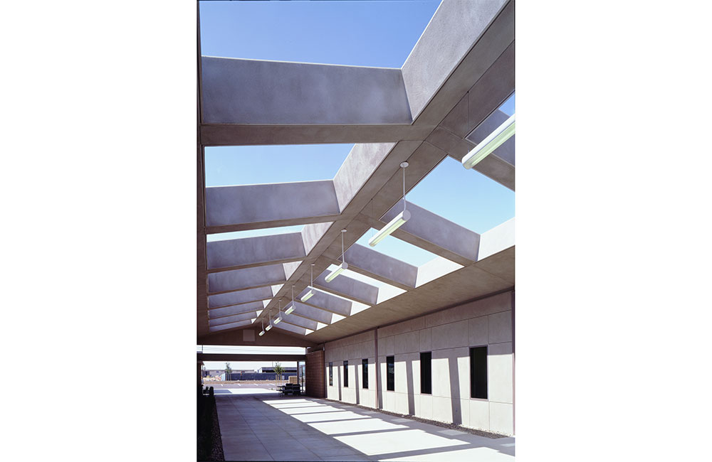 Image 4. Outdoor walkway with beams above supporting suspended linear light fixtures.