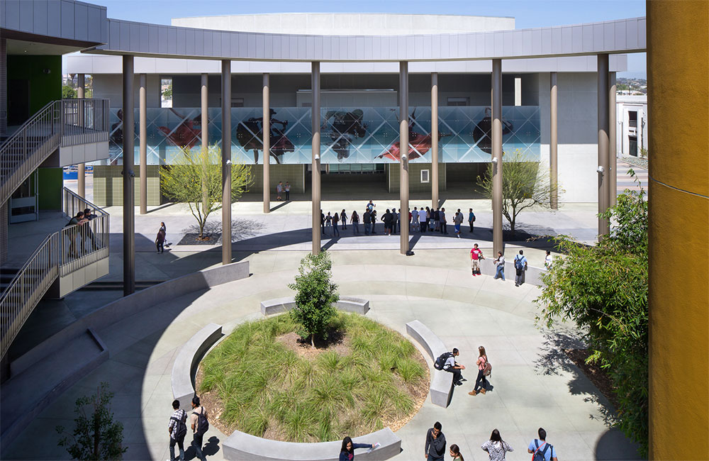 Image 3. View of the courtyard from the third level walkway showing a circular mound filled with plants in the center and a ring of concrete benches located along the perimeter of the planting area.