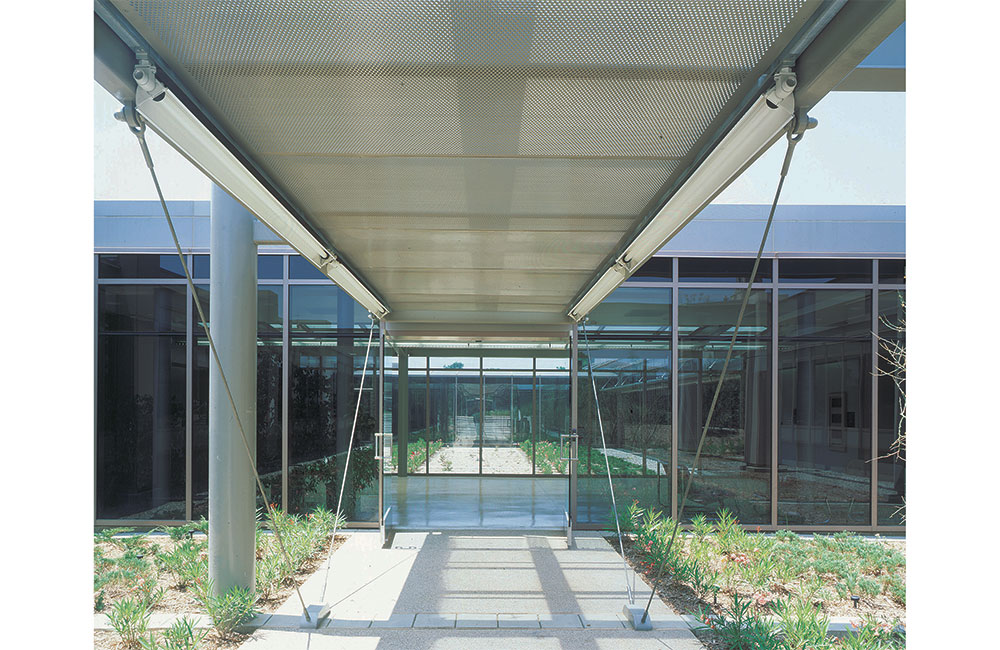 Image 3. Side view of building showing full-height storefront system and entry doors with metal canopy above.