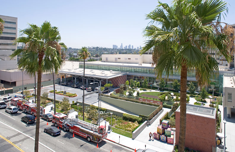 Image 1. Aerial exterior view of hospital showing brick clad entry lobby on the left and small outdoor park on the right.